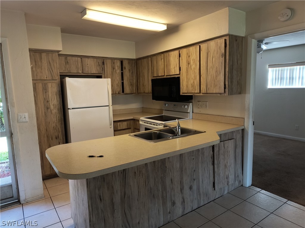 1100 Pondella Road, Unit 1001 Cape Coral, FL 33909 - Photo 3 of 14 a kitchen with a refrigerator a sink and a refrigerator