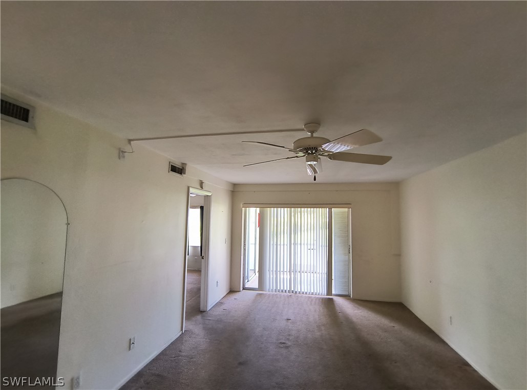 1100 Pondella Road, Unit 1001 Cape Coral, FL 33909 - Photo 5 of 14 an empty room with chandelier fan and windows