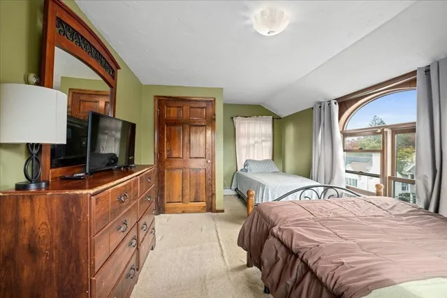 a bedroom with a bed and a flat tv screen on dresser