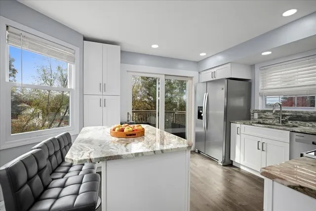 a kitchen with stainless steel appliances granite countertop a refrigerator a sink a stove and island