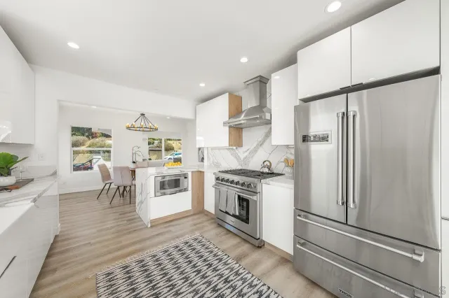 a kitchen with stainless steel appliances granite countertop a refrigerator a stove and a refrigerator