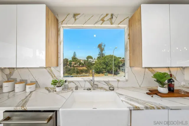 a bathroom with a sink a mirror and a potted plant