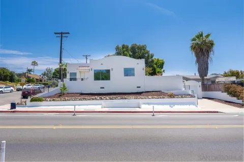 a view of a house with a street and car parked
