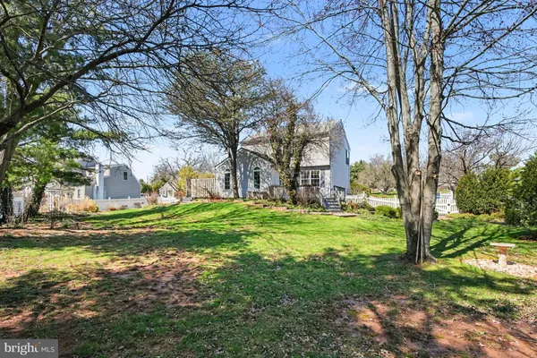 a front view of a house with a garden and trees