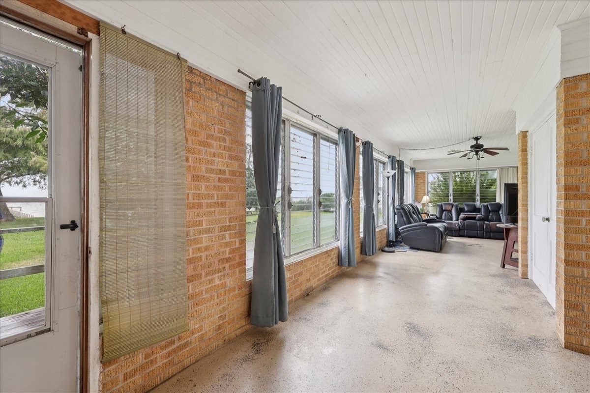 11910 Cedar Gully Road Beach City, TX 77523 - Photo 19 of 50 a view of a balcony with couch and floor to ceiling window