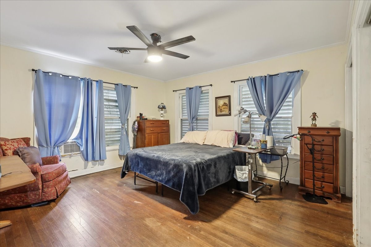 11910 Cedar Gully Road Beach City, TX 77523 - Photo 40 of 50 a bedroom with a bed and wooden floor