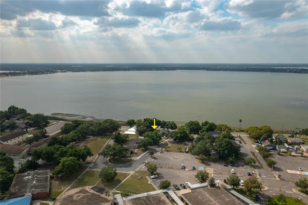 an aerial view of a city with lots of residential buildings ocean and mountain view in back