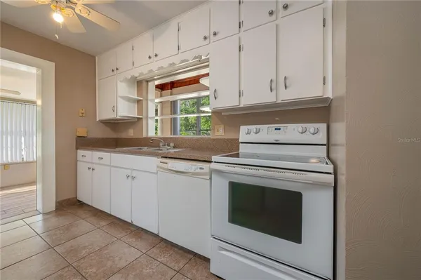 a kitchen with granite countertop white cabinets and white appliances