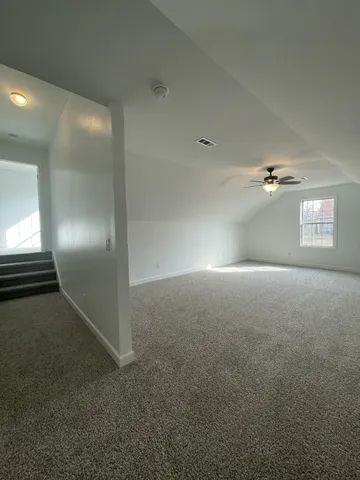 an empty room with windows and ceiling fan