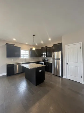 a large kitchen with a large counter top stainless steel appliances and cabinets
