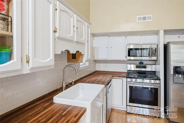a kitchen with stainless steel appliances a stove a sink and a microwave