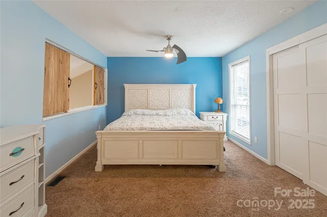 a large bed sitting in a room next to a window