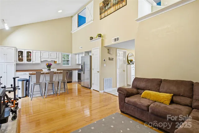 a living room with furniture and a dining table with kitchen view