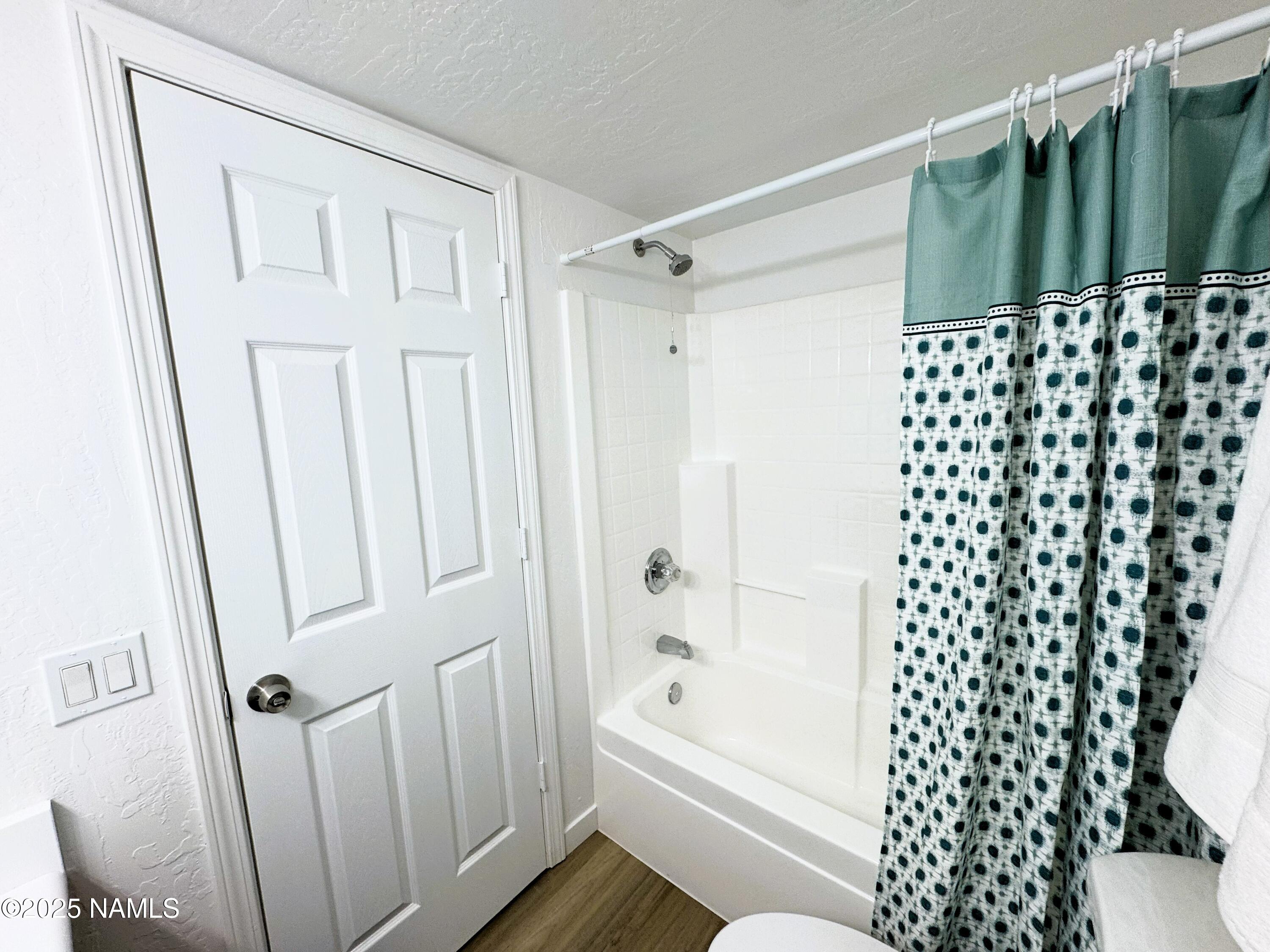 1807 North Main Street Flagstaff, AZ 86004 - Photo 11 of 26 a bathroom with a shower curtain and a toilet