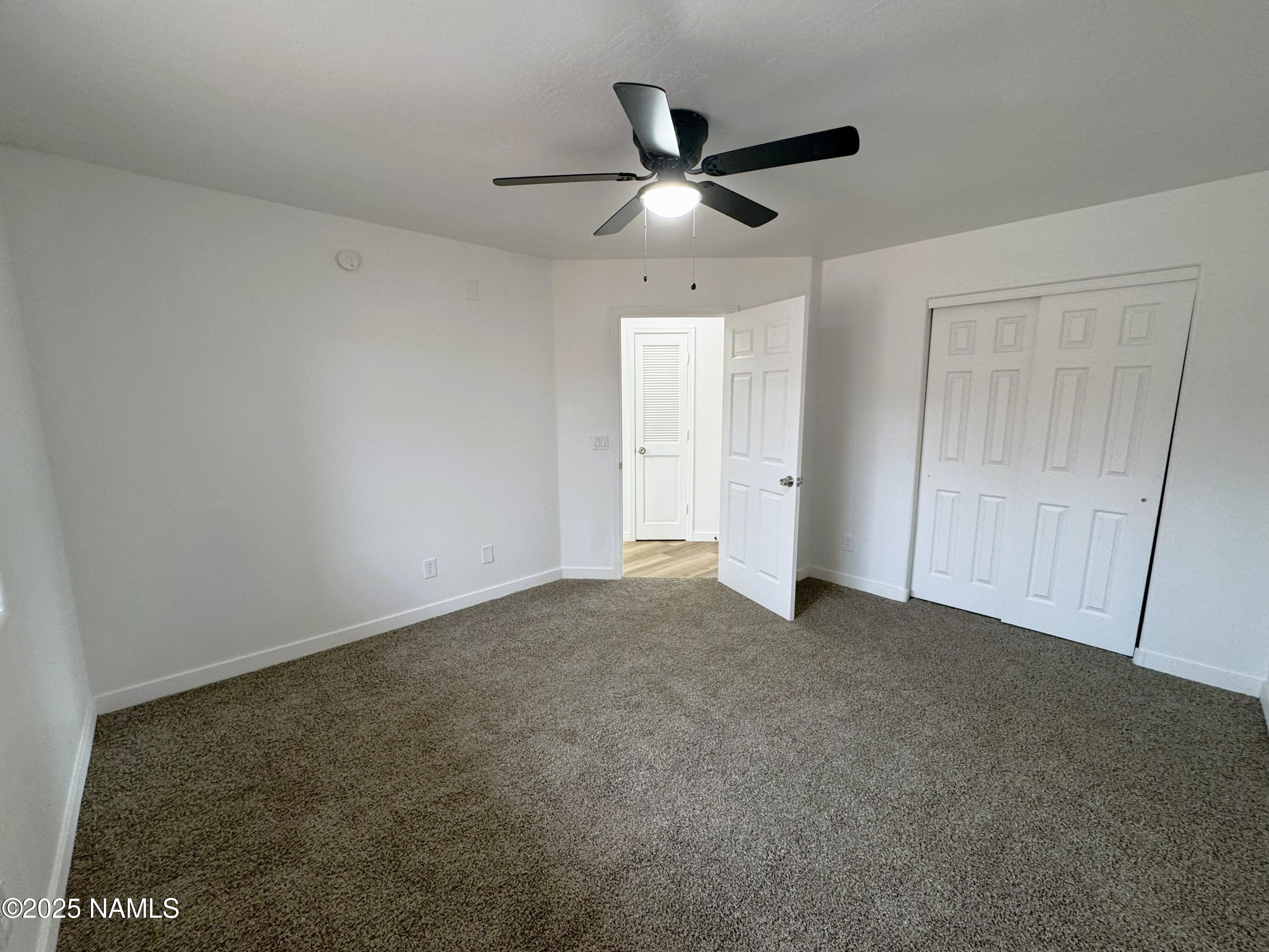1807 North Main Street Flagstaff, AZ 86004 - Photo 13 of 26 an empty room with a ceiling fan and window
