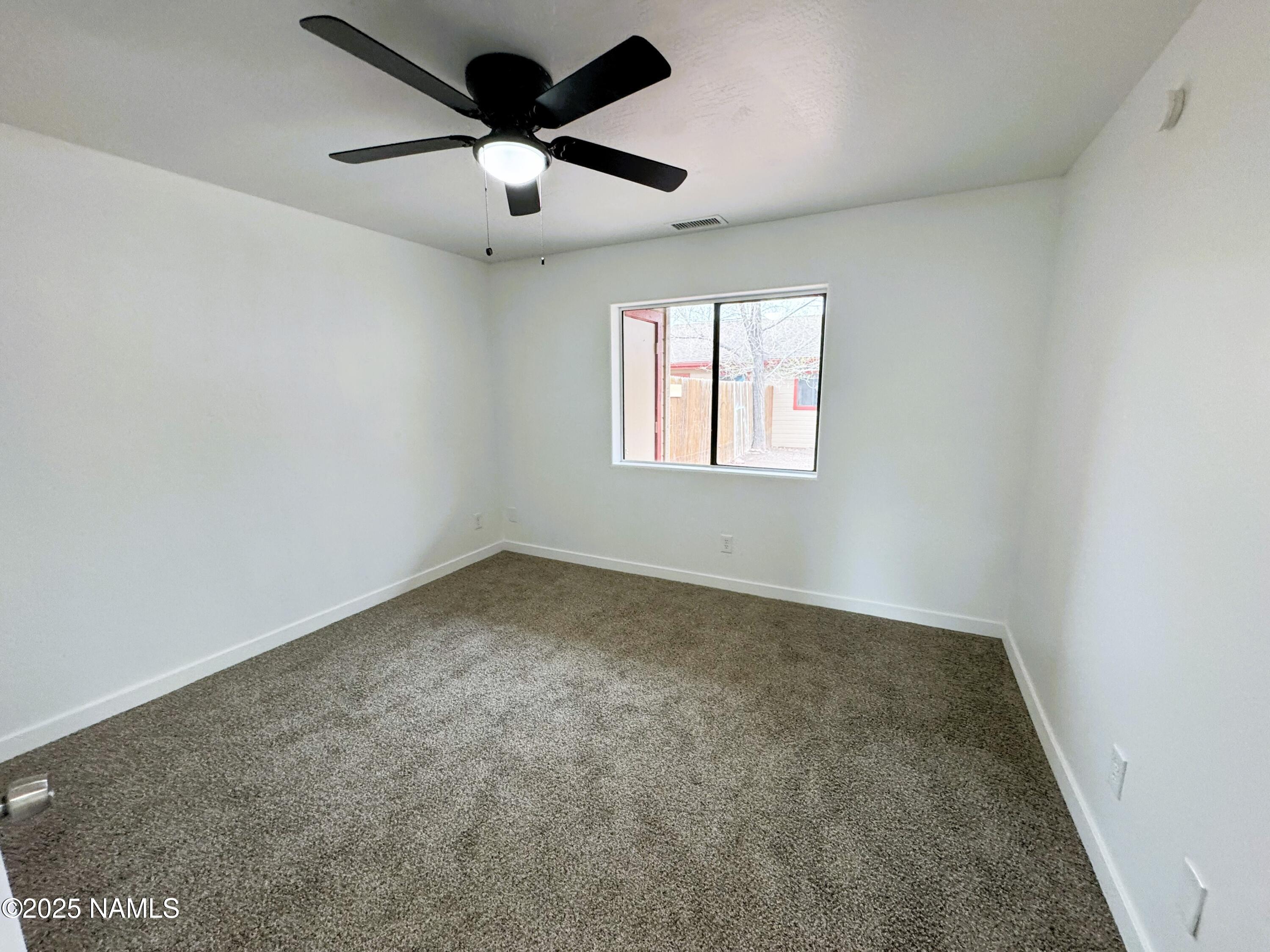 1807 North Main Street Flagstaff, AZ 86004 - Photo 14 of 26 an empty room with a ceiling fan and window