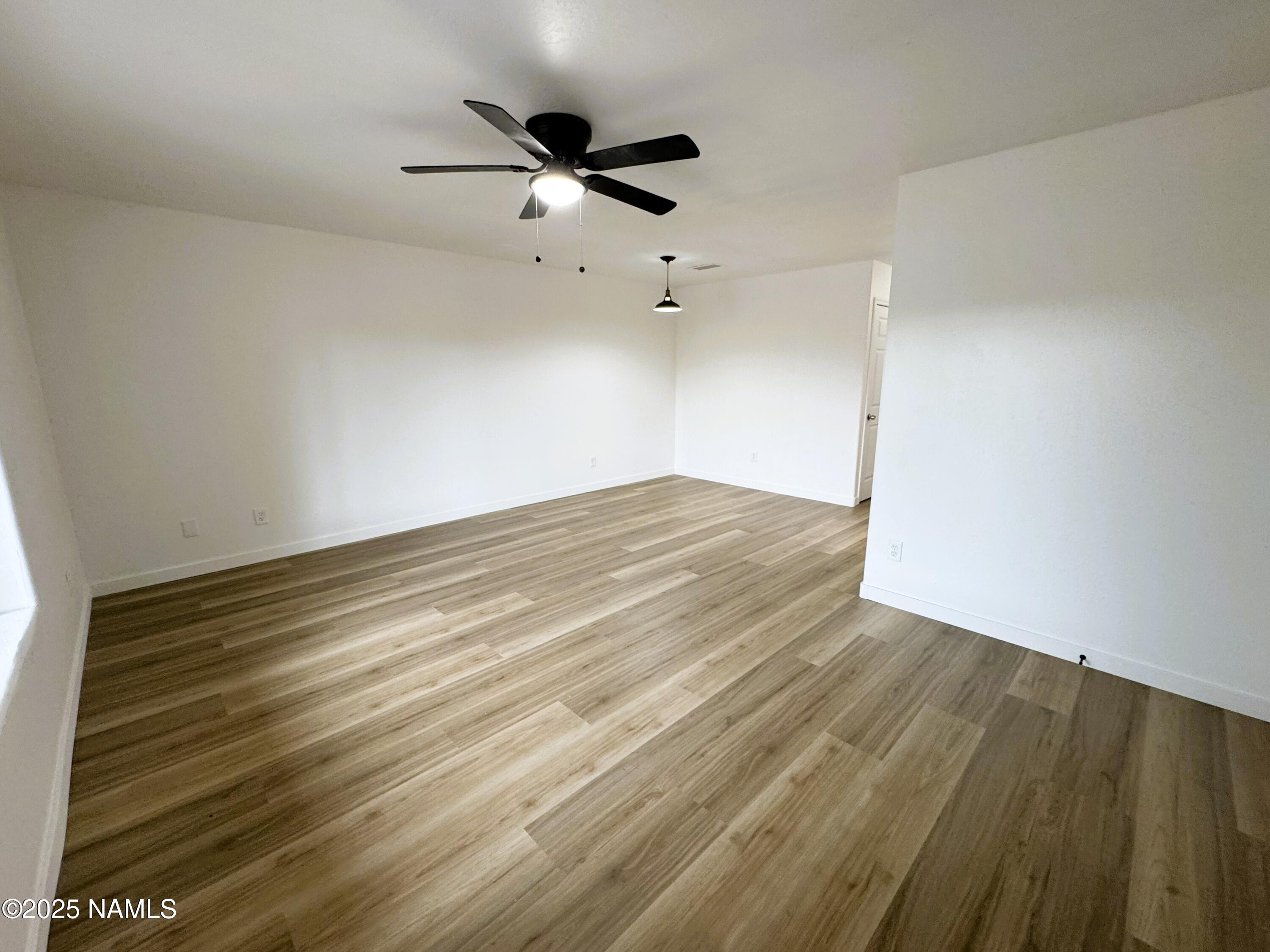 1807 North Main Street Flagstaff, AZ 86004 - Photo 5 of 26 an empty room with wooden floor fan and windows