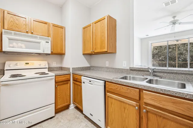 a kitchen with appliances a sink and cabinets