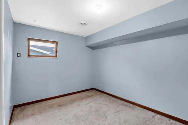 an empty room with closet and a window