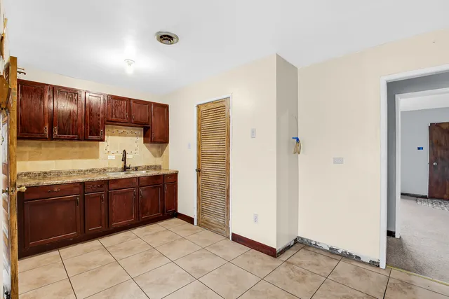 a large kitchen with granite countertop a refrigerator and a sink