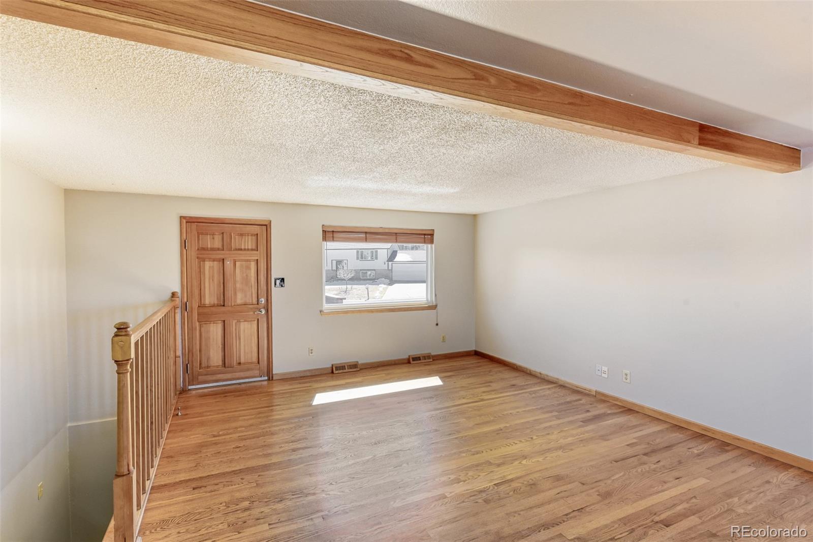 128 Olympus Circle Lone Tree, CO 80124 - Photo 12 of 35 a view of an empty room with wooden floor and a window
