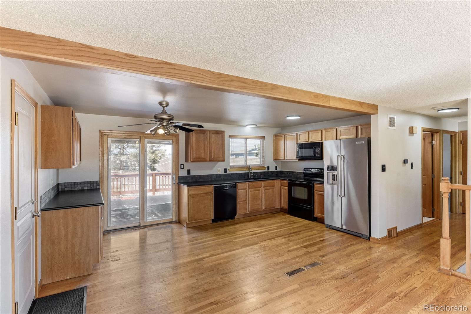 128 Olympus Circle Lone Tree, CO 80124 - Photo 13 of 35 a large kitchen with a refrigerator and wooden cabinets