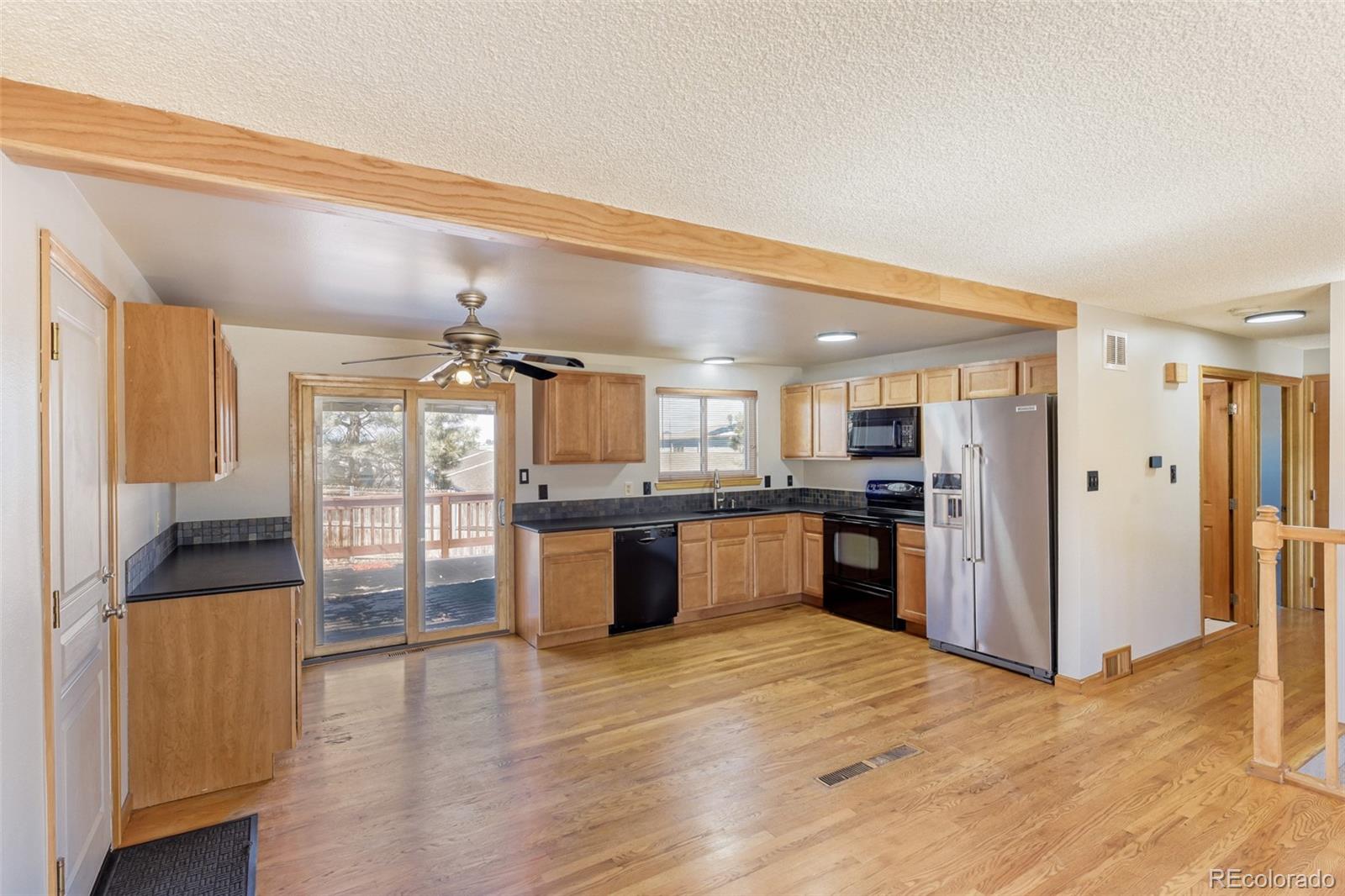 128 Olympus Circle Lone Tree, CO 80124 - Photo 14 of 35 a large kitchen with a large counter top a refrigerator and cabinets