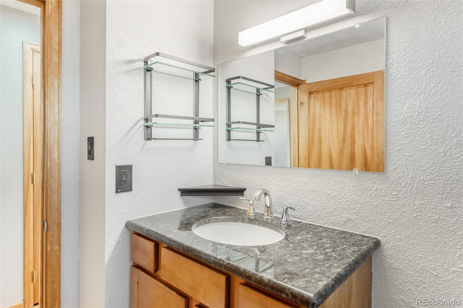 128 Olympus Circle Lone Tree, CO 80124 - Photo 28 of 35 a bathroom with a granite countertop sink and a mirror