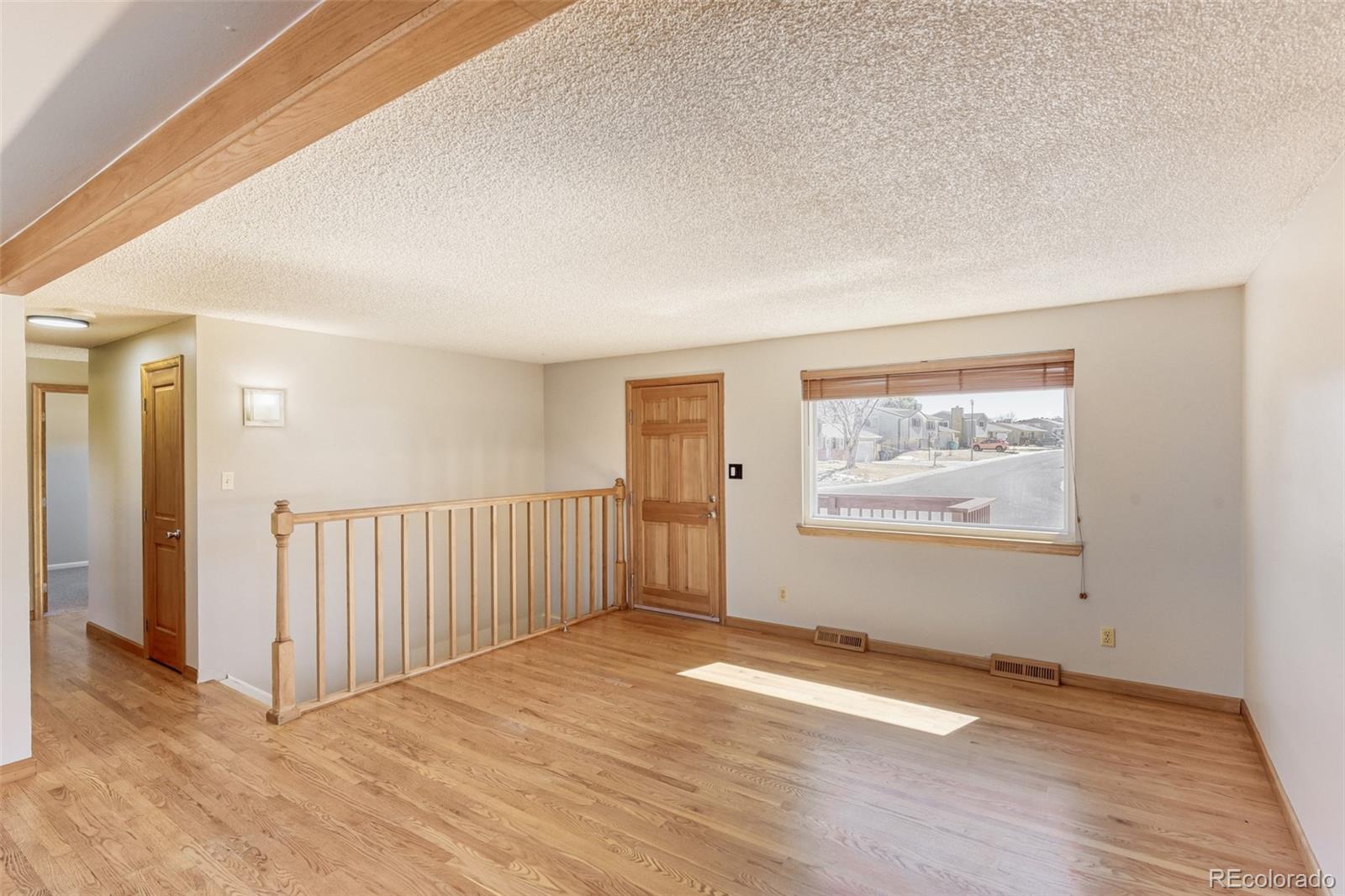 128 Olympus Circle Lone Tree, CO 80124 - Photo 4 of 35 an empty room with wooden floor and windows