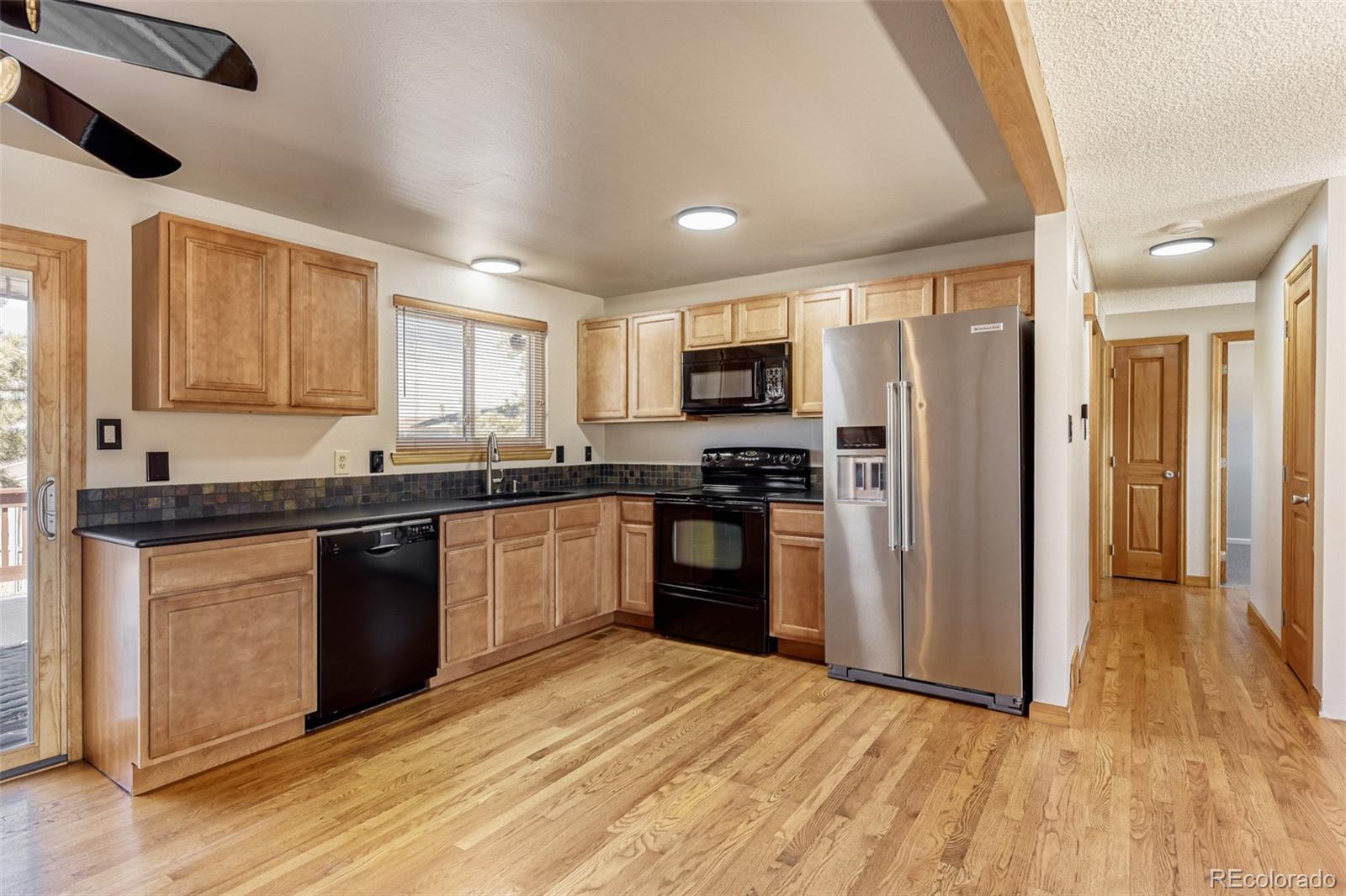 128 Olympus Circle Lone Tree, CO 80124 - Photo 7 of 35 a kitchen with granite countertop a refrigerator stove top oven and sink