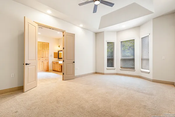 an empty room with closet and a chandelier fan