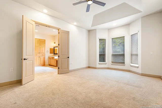 an empty room with closet and a chandelier fan