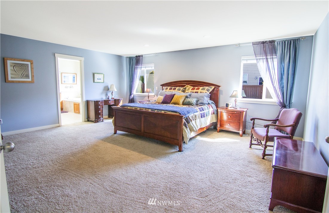 21915 39th Drive Southeast Bothell, WA 98021 - Photo 22 of 36 a spacious bedroom with a bed a couch and a window