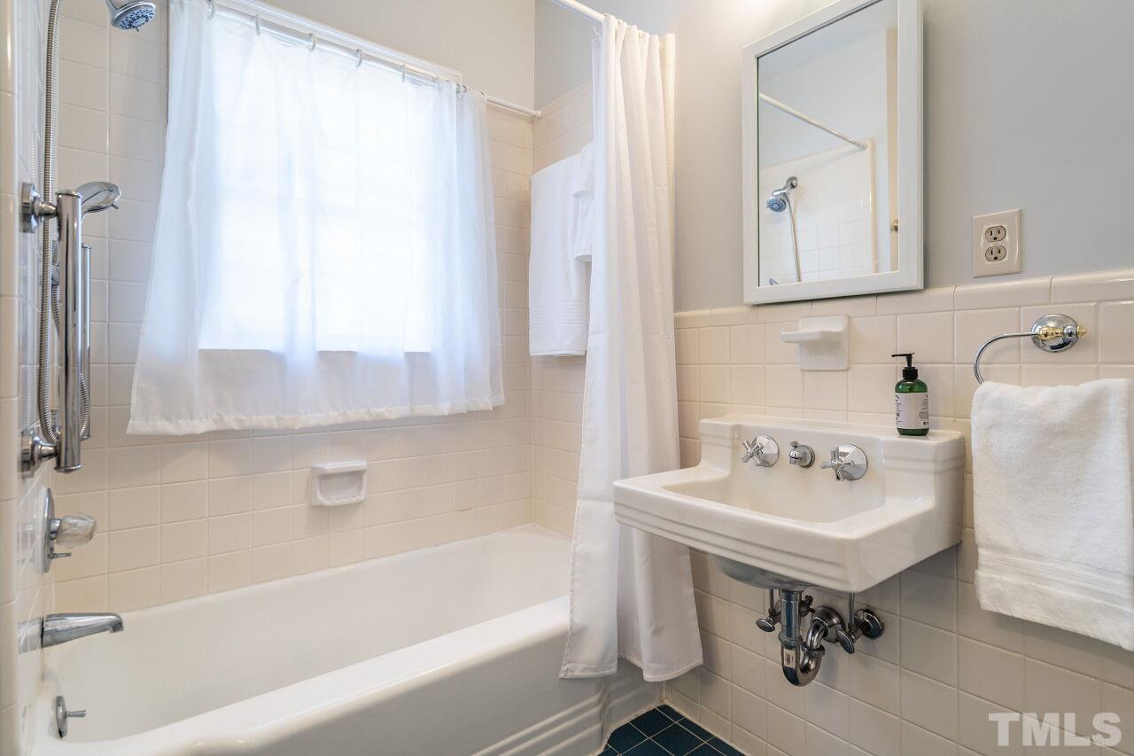 5212 Theys Road Raleigh, NC 27606 - Photo 30 of 55 a bathroom with a sink mirror and a bathtub