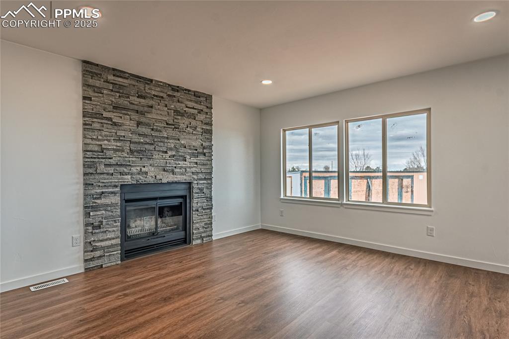 12480 Partridge Lane Peyton, CO 80831 - Photo 9 of 38 a view of an empty room with wooden floor fireplace and a window