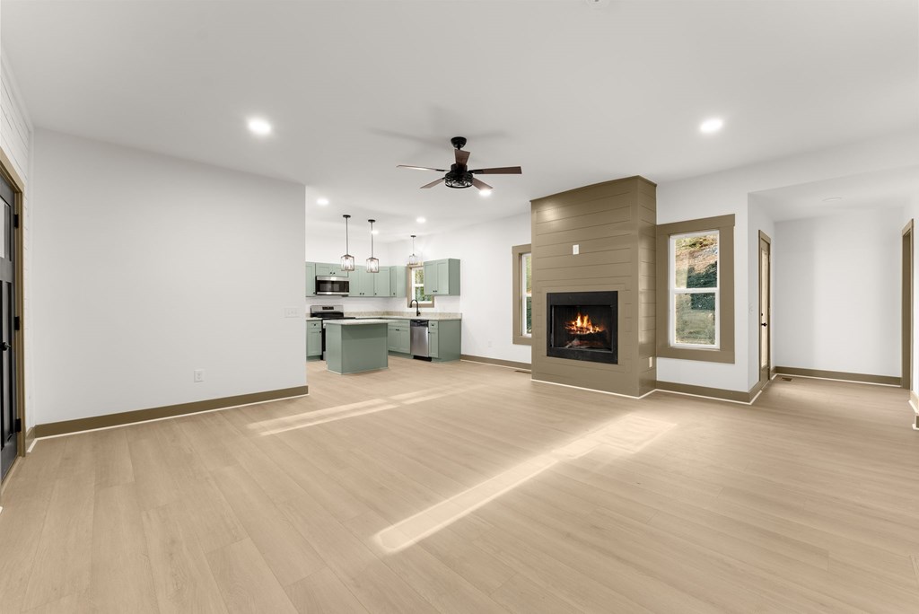 1410 Sky Lake Road Sautee Nacoochee, GA 30571 - Photo 6 of 37 a view of a livingroom with a fireplace a ceiling fan and windows