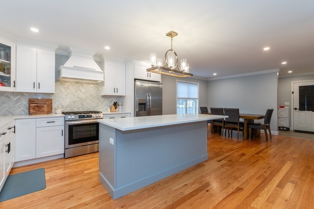 21 Juniper Road Norton, MA 02766 - Photo 8 of 33 a kitchen with stainless steel appliances granite countertop wooden floor a stove top oven a sink counter space and cabinets