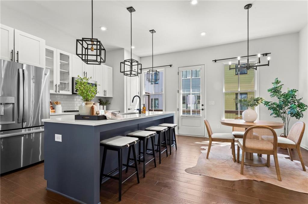 718 Needletail Way Atlanta, GA 30312 - Photo 9 of 44 a kitchen with stainless steel appliances granite countertop a table chairs stove and refrigerator