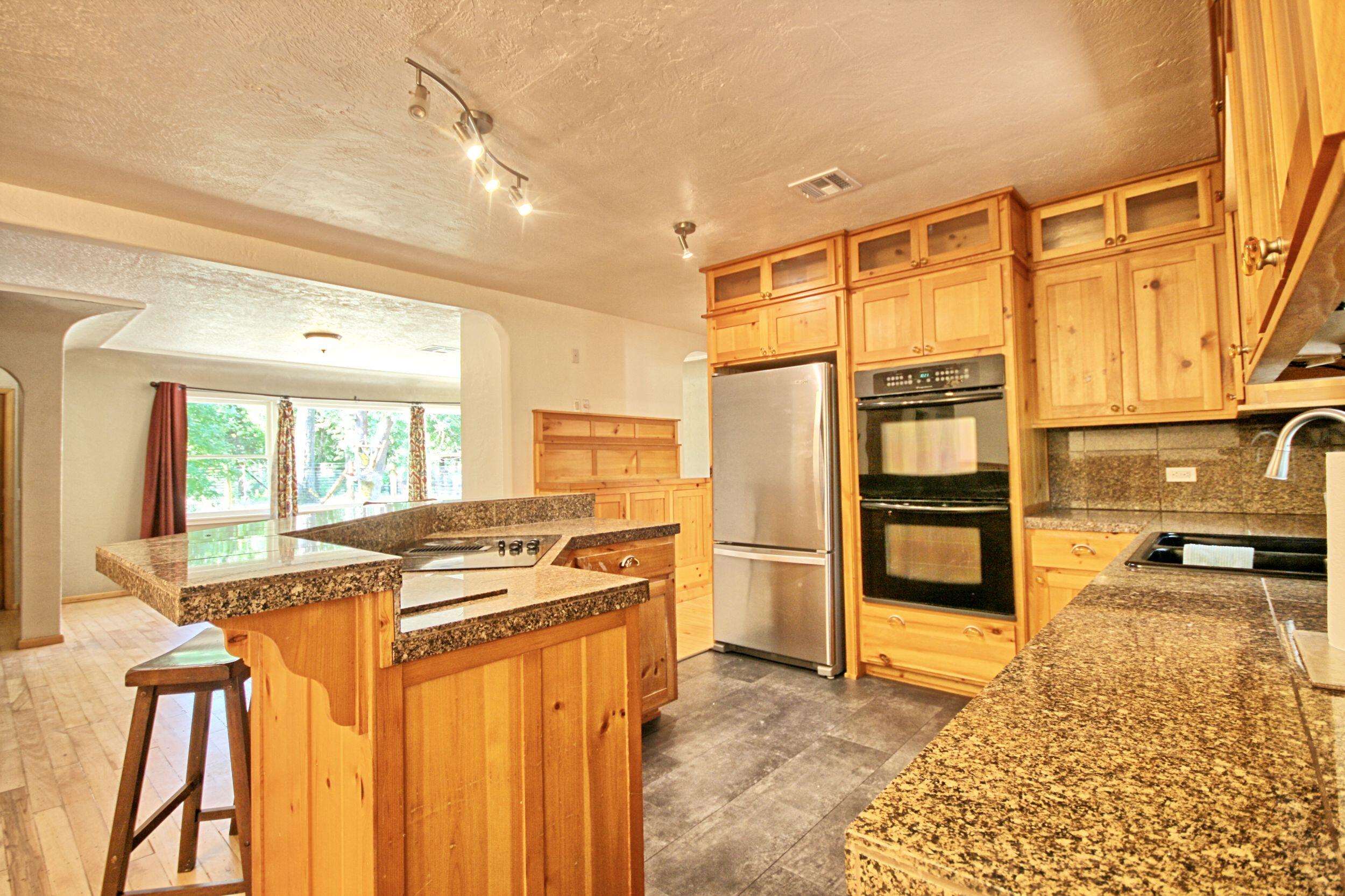 199 Powell Creek Road Williams, OR 97544 - Photo 21 of 57 a kitchen with stainless steel appliances granite countertop a stove a sink and a refrigerator