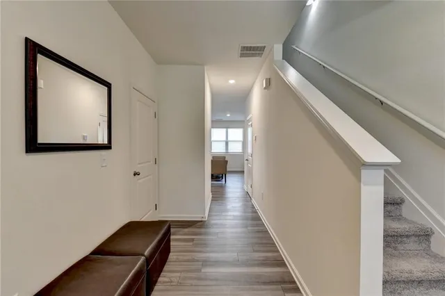 a view of a hallway with wooden floor and staircase