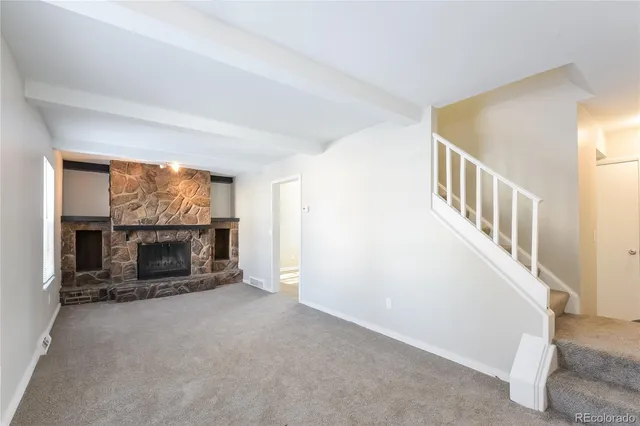 a view of an empty room with a fireplace and a window