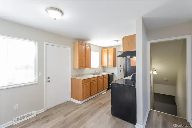 a kitchen with granite countertop a refrigerator and cabinets