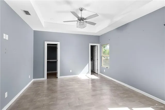 an empty room with closet and windows