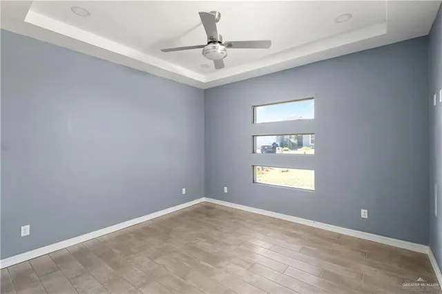 an empty room with a window and a ceiling fan
