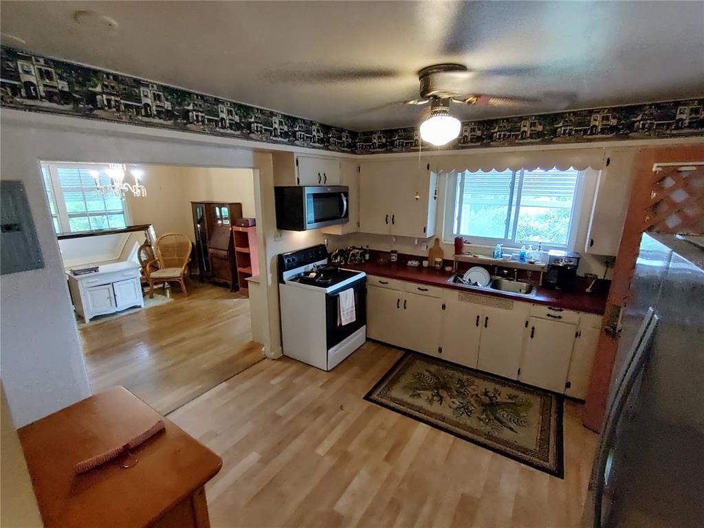 995 West 11th Avenue Mount Dora, FL 32757 - Photo 19 of 49 a kitchen with stainless steel appliances a stove a sink a refrigerator and a dining table