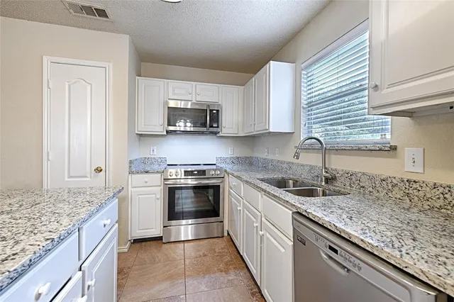 a kitchen with stainless steel appliances granite countertop a sink stove and cabinets