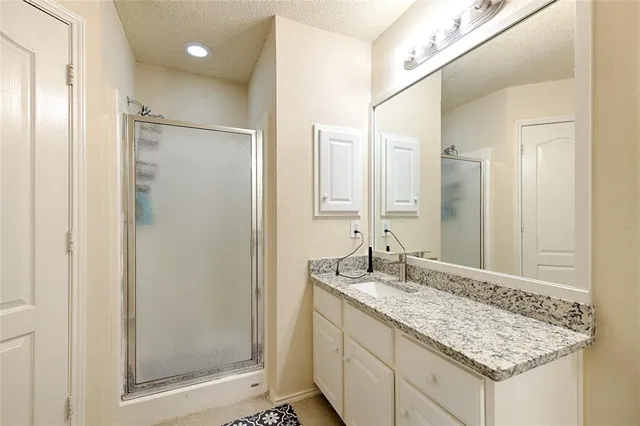 a bathroom with a granite countertop sink and a bathtub