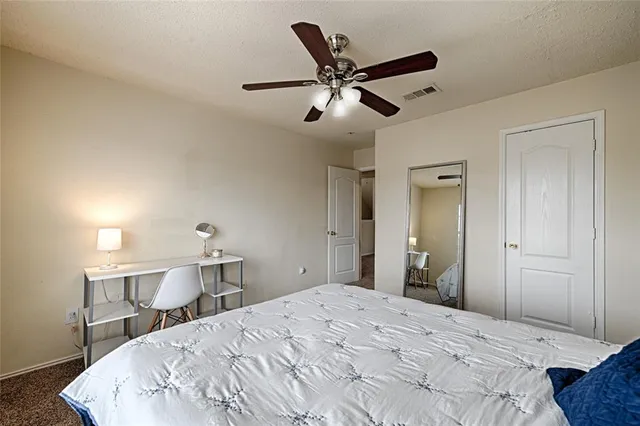 an empty room with windows and fan