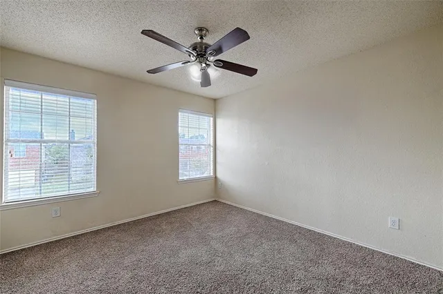 an empty room with closet and a chandelier fan