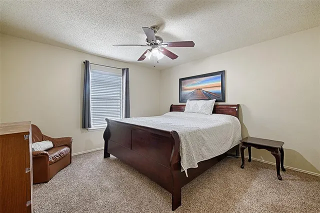 a bedroom with a bed and a ceiling fan